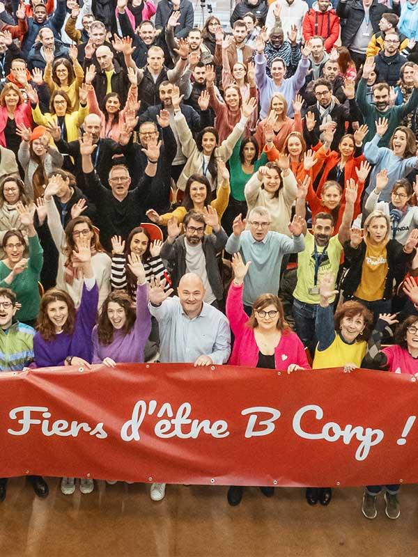 Groupe de collaborateurs Expanscience tenant une banderole Fiers d'être B Corp