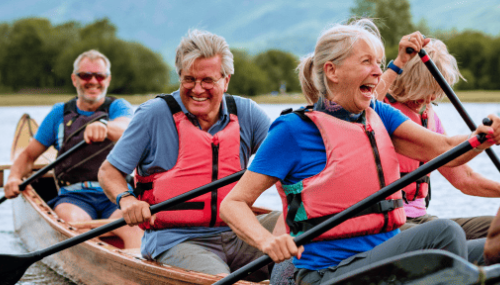 Des gens qui rient en pagayant dans un canoë
