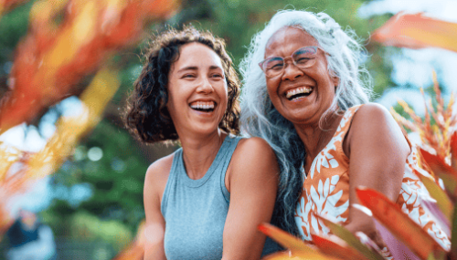 Deux femmes riant ensemble au milieu de plantes