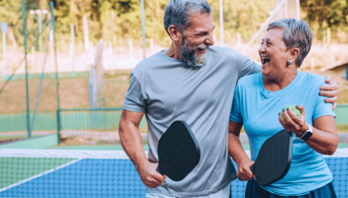 Un couple qui rit sur un court de pickleball