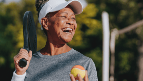 Une femme qui rit en jouant au pickleball