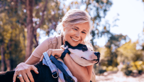Une femme qui sourit en serrant un chien