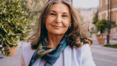 Portrait souriant d'une femme aux cheveux gris avec une écharpe