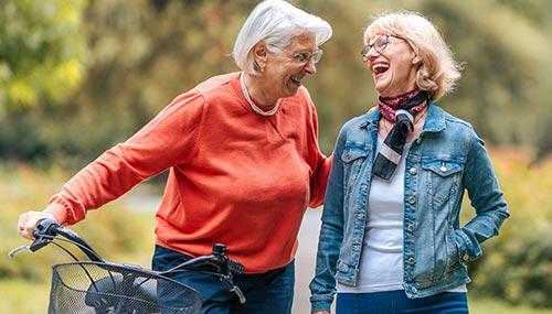 Deux femmes âgées souriantes à vélo