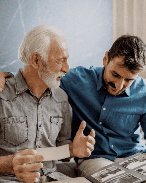 Homme âgé avec homme plus jeune regardant un album photos