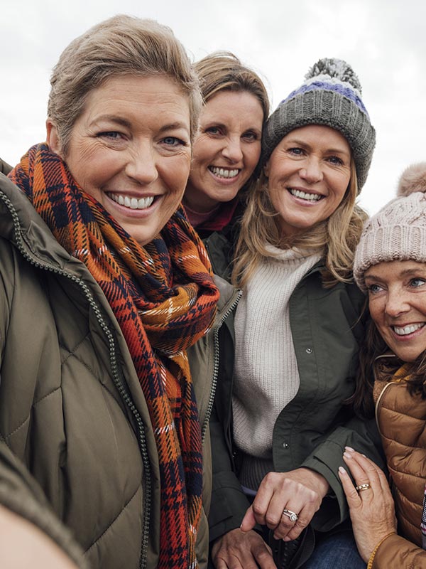 Groupe de femmes qui sourient habillées chaudement